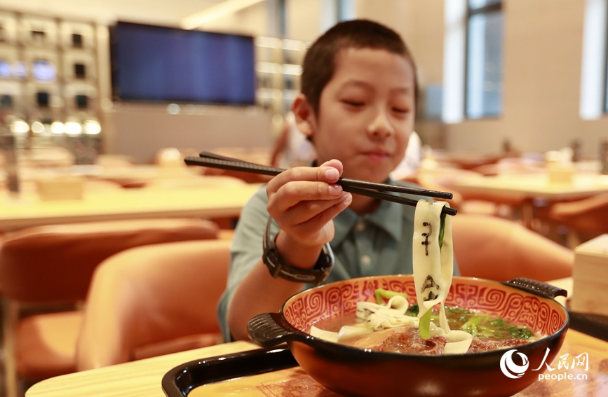 殷墟博物館推出的甲骨文面深受游客喜愛。人民網(wǎng)記者 慎志遠 攝